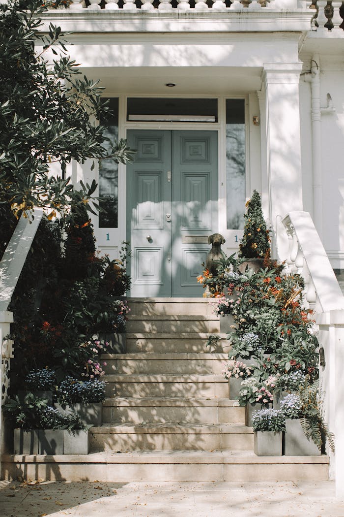 Elegant English home entrance adorned with colorful flowers and classic architecture.